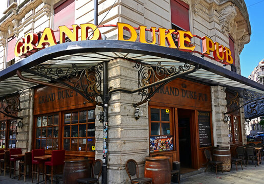 Geneva, Switzerland, Europe - 05.2026 : Sign of Grand Duke Pub, Art Nouveau style roofing above entrance, outdoor tables, menu on window, Rue de Monthoux in city center near Cornavin train station
