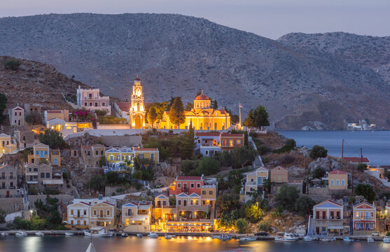 Illuminated Orthodox Church Above Symi Harbor at Blue Hour on Symi Island Greece