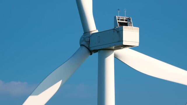 Close-Up of Wind Turbine Nacelle and Blades Against Blue Sky