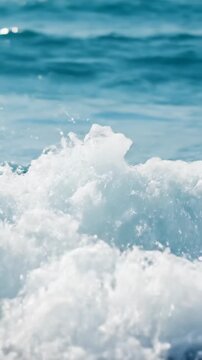 slow motion video of ocean waves rolling and breaking creating vibrant white foam on clear blue sea water surface