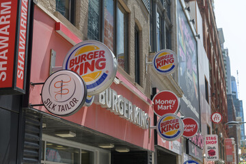 Fototapeta premium wall-mounted round projecting signs of Silk Tailor, Burger King, Money Mart, on Yonge St, Toronto
