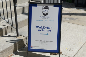 Fototapeta premium a-frame sidewalk sign outside Old English Grooming Club, a high-end luxury men's barbershop and social lounge, located at 28 Scollard St, Toronto
