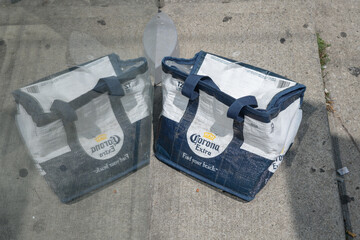 Fototapeta premium old, discarded 12-pack carrier with Corona brewery logo and slogan on a sidewalk next to a bus stop in summer, Toronto