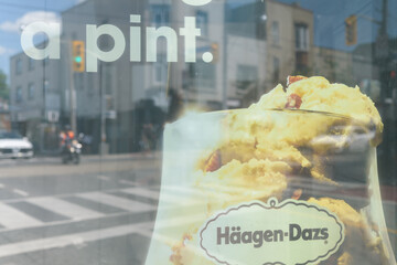 Fototapeta premium OOH advertising poster at a grungy bus shelter for Häagen-Dazs EXTRÄAZ Maple Almond Toffee Ice Cream, Toronto