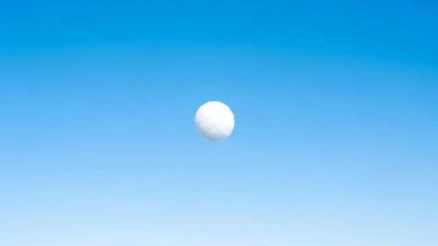 Minimalist conceptual image of a single white spherical cloud floating in a vast clear blue sky