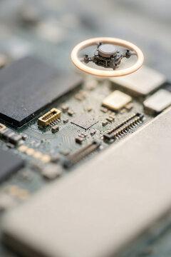 Miniature drone hovering over a computer circuit board