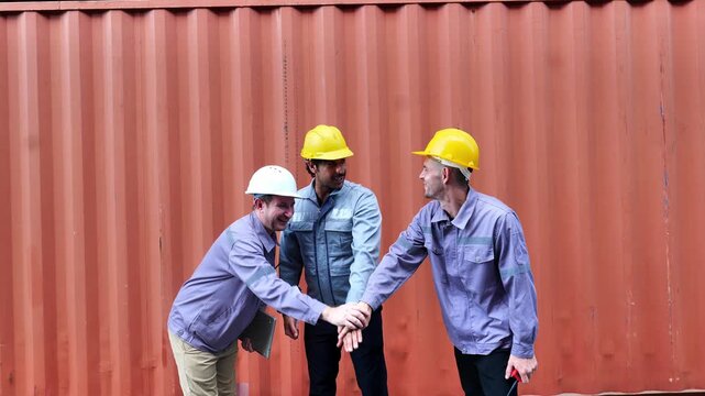 Vdo slow motion group of diversity teamwork engineer and worker in safety uniform are morning talk and putting hands let unite to starting work in The loading area with container stacked in the back.