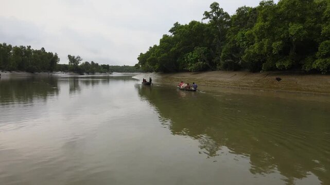 Khulna, Bangladesh &ndash; March 20, 2025: Local Fishermen Rowing Wooden Boats Through Sundarbans Mangrove Forest River, Bangladesh. The Sundarbans