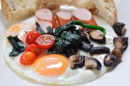 fried egg or sunny side up egg with vegetable topping and bread or breakfast