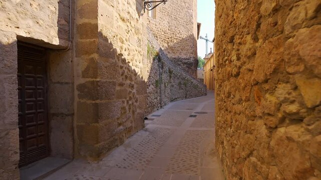 Narrow cobbled alley between old stone walls in the historic center of Cuenca, Castilla La Mancha