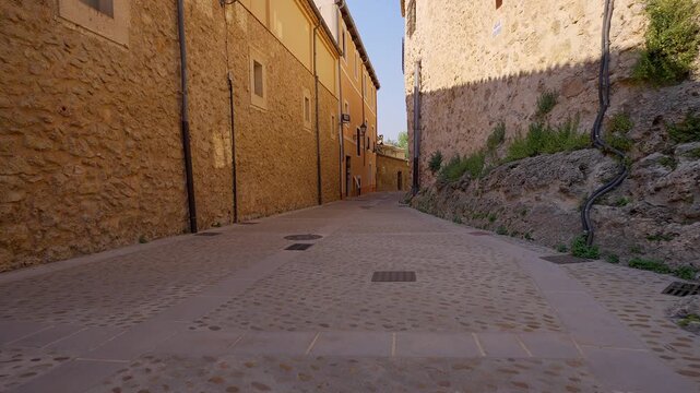Quiet cobbled street bordered by historic stone buildings in Cuenca, Castilla La Mancha
