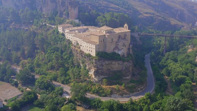 Hillside gardens and winding road beneath the cliffs of historic Cuenca in Castilla La Mancha