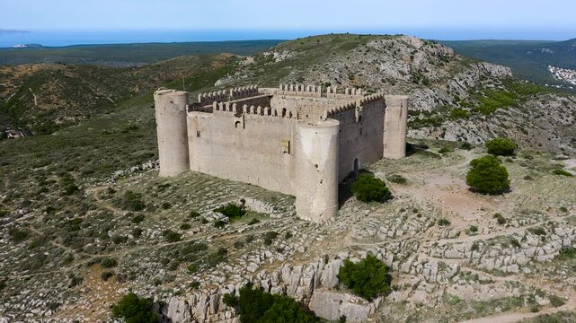 Aerial view of Torroella de montgri castle ruins, a medieval fortresses in Catalonia, standing atop a wooded hill and dominating the landscapes of la Pals Bay. 