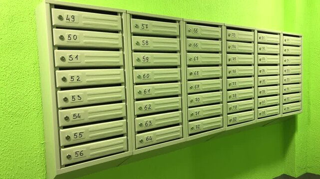 Rows of numbered apartment mailboxes in a residential building entrance, postal delivery, housing infrastructure and urban communication.