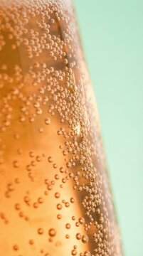 Macro view golden bubbles inside glass against green background. Refreshing festive atmosphere with sparkling details. Perfect for beverage marketing or celebration designs.