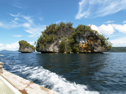 A boat enters the spectacular limestone island landscape of Raja Ampat. Photographed during the transfer from Sorong between islands of Waigeo and Gam