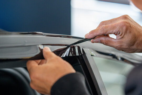 A car wrapping specialist applies a polyurethane film to the car. Detailer PPF