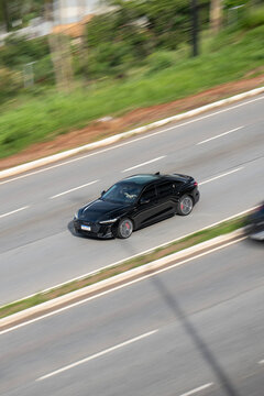 Black Audi RS7 driving panning shot, High performance luxury sportback on highway