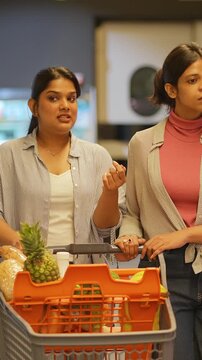 Indian women lesbian talking and shopping together in a supermarket