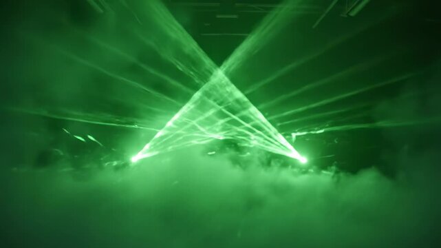 Green laser beams cut through thick stage smoke. Dynamic light show creates atmosphere in dark room. Neon nightclub performance effect.
