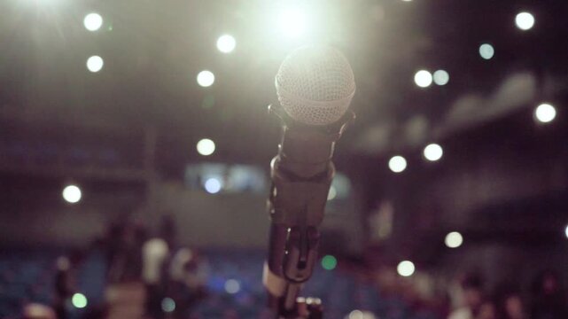 Professional stage microphone with a blurred audience in the background
