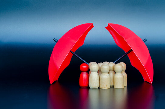Leadership team gathered under umbrella symbolizing collective protection, insurance safety, and reliable guidance.