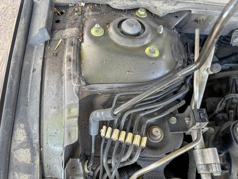 Close-up of automotive suspension and brake components beneath a car hood, vehicle inspection and mechanical maintenance.