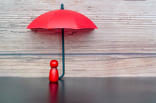 Red umbrella sheltering a single leader figure symbolizing insurance coverage, security, and responsible leadership.