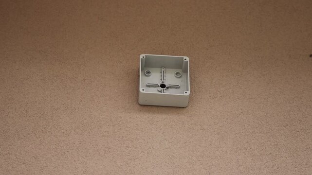 Wall-mounted junction box with a cable emerging through the opening, prepared for CCTV security camera installation.