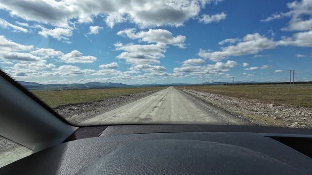 POV driving across Flatruet mountain plateau in Sweden. First-person view on a scenic gravel road through vast highland landscapes with mountains, tundra and open wilderness.