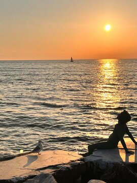 The sculptures at sunset by the Viareggio artist Libero Maggini located on the pier of Viareggio are part of a famous bronze artistic complex entitled Maggio, Viareggio, Italy