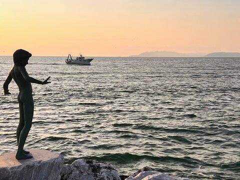 The sculptures at sunset by the Viareggio artist Libero Maggini located on the pier of Viareggio are part of a famous bronze artistic complex entitled Maggio, Viareggio, Italy