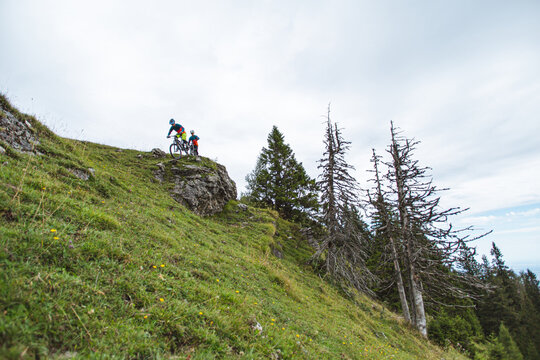 Mountain bikers riding across an alpine meadow in the Austrian Alps