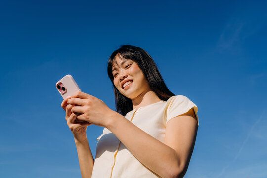 A woman using a mobile phone standing outdoors