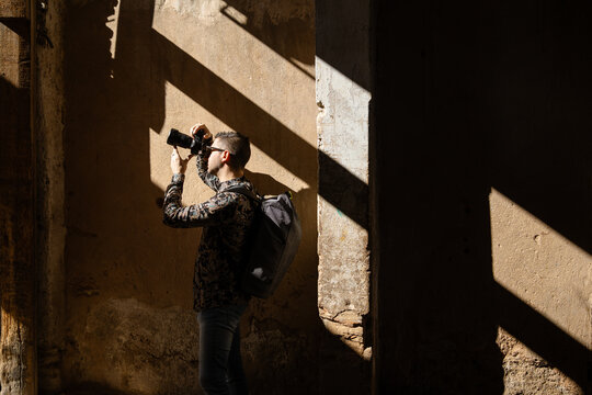 A man taking photos  in an alley in a medina in Morocco