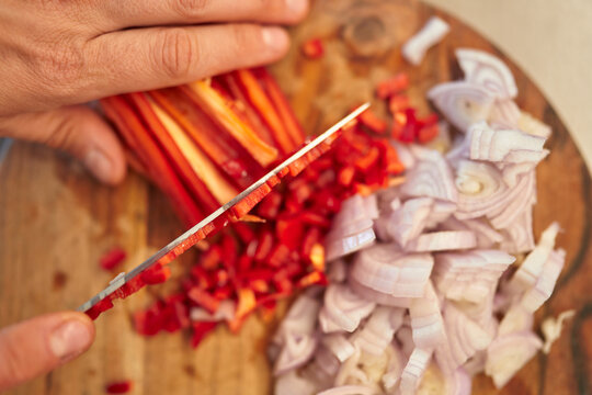 Chef Chopping Fresh Red Peppers and Onions