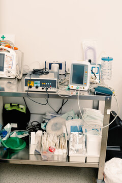 Steel trolley holds electronic monitors above medical supplies
