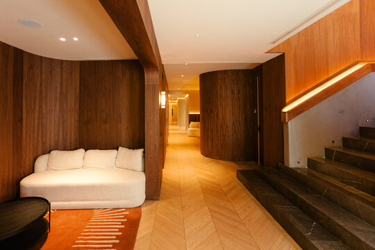 Modern clinic with wood walls, white sofa, and illuminated hallway.