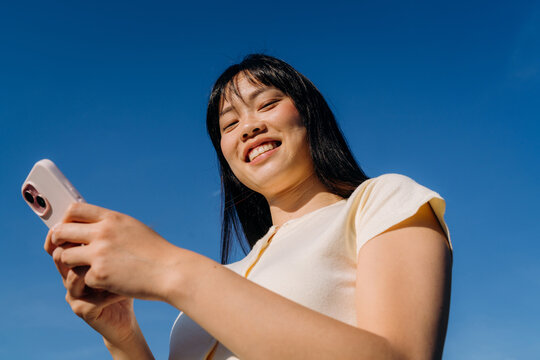 A woman using a mobile phone standing outdoors
