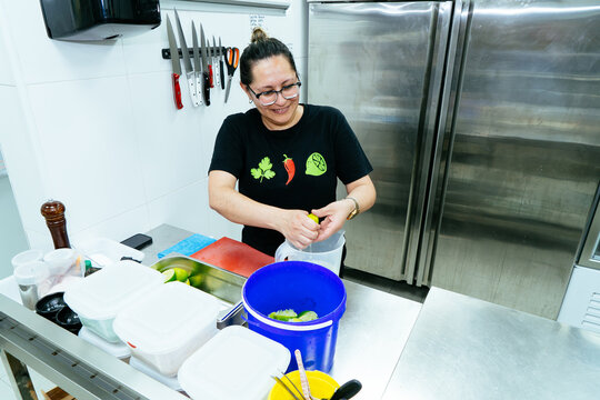 Woman chef squeezing fresh limes in professional kitchen