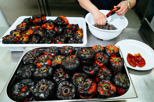 Peeling roasted red bell peppers in commercial kitchen