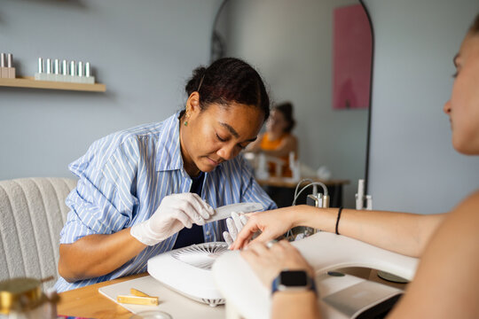 Nail artist shaping natural nails by hand