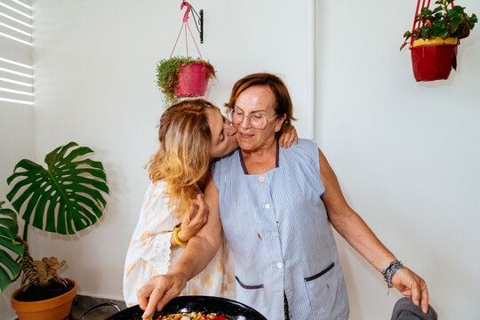 Mother and daughter cooking paella demonstrating family love