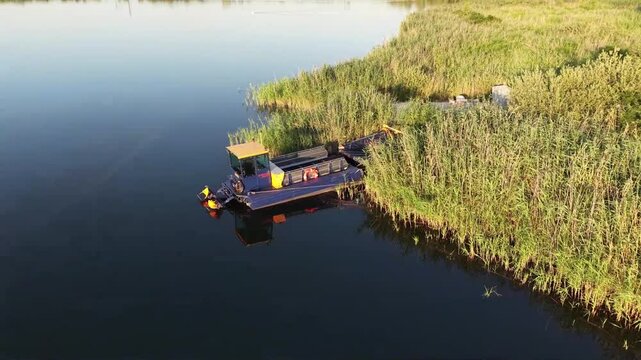 Aerial view of an aquatic weed harvester cleaning a lake