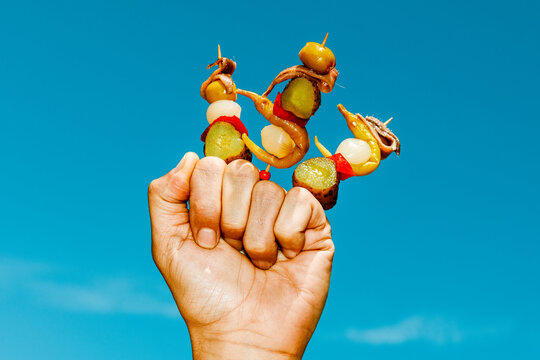 a man presents assorted banderillas, a traditional spanish bar snack