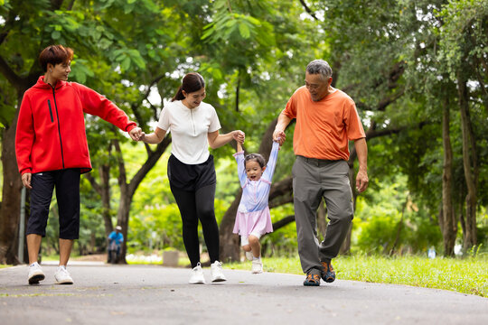 Family exercising and walking together in city park summer. healthy lifestyle in nature. Father mother, kids daughter exercise. Family team, children. healthy lifestyle and family bonding