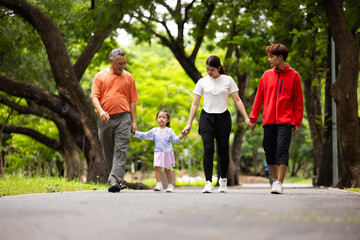 Fototapeta premium Parents are here reate perfect day for childrent. Father and mother hands and raise her up and walk. exercising and walking together in city park summer. healthy lifestyle in nature. family bonding