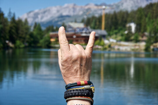 Rock-on hand sign with lake view, Crans-Montana