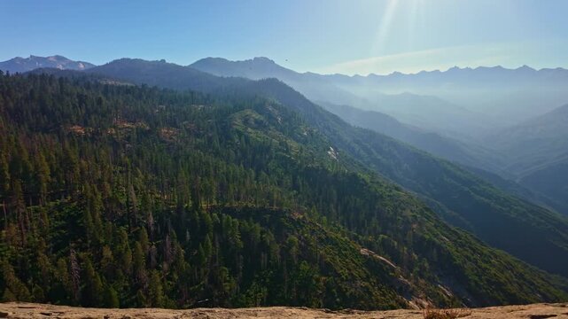Golden sunrise light glows across the sweeping panoramic vista of Sequoia National Park from Moro Rock