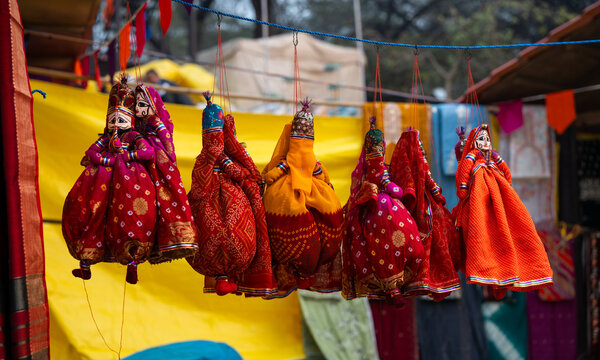 Colorful handmade Rajasthani puppets (Kathputli) hanging for sale at a traditional handicraft market in India. Ideal for Indian culture, folk art, tourism, heritage and handcrafted souvenir concepts